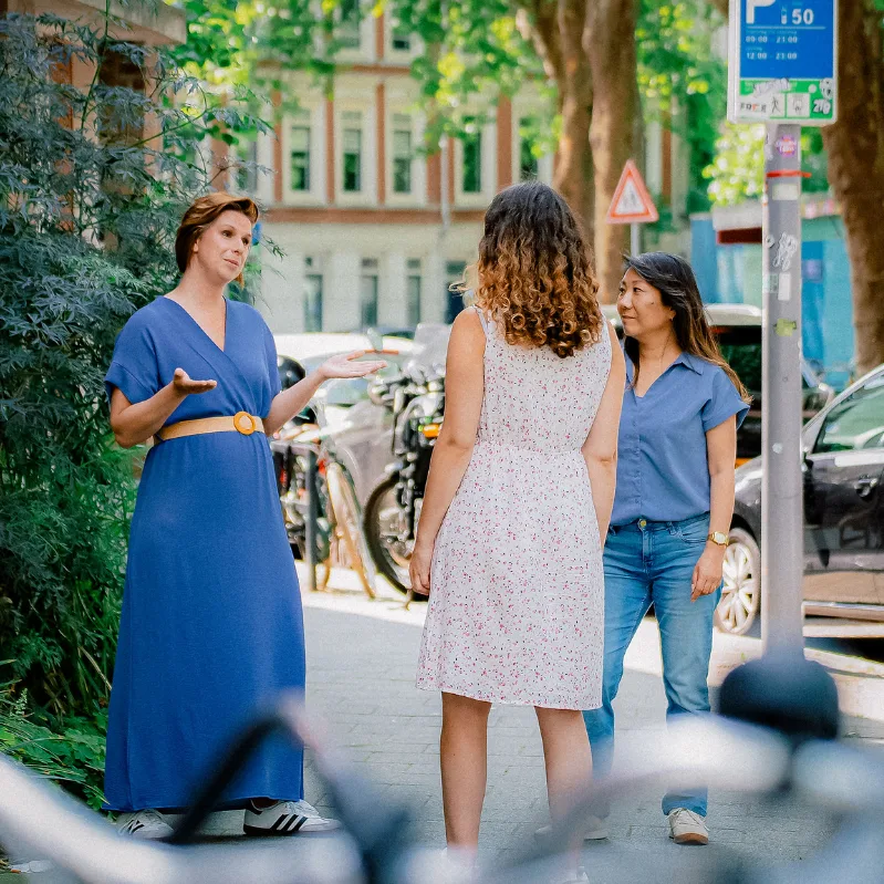 Twee behandelaren spreken een cliënte op straat